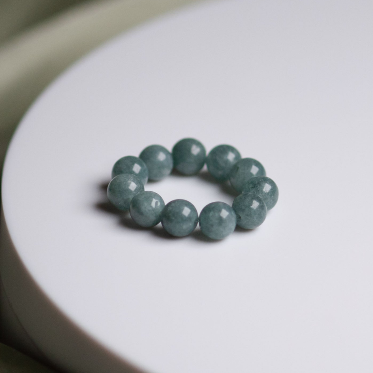 Blue Spruce 6 mm Perlenring elastisch an der Hand vor weißem Hintergrund